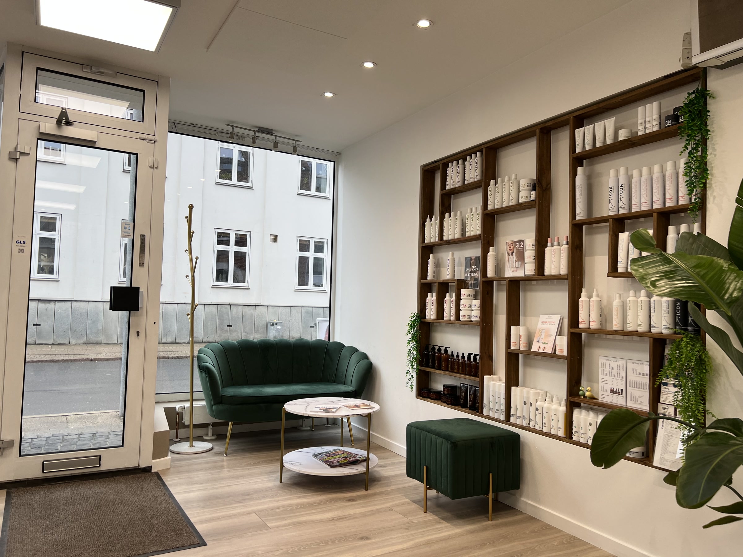 Venteområde med stol og planter i Hair4You-salonen.